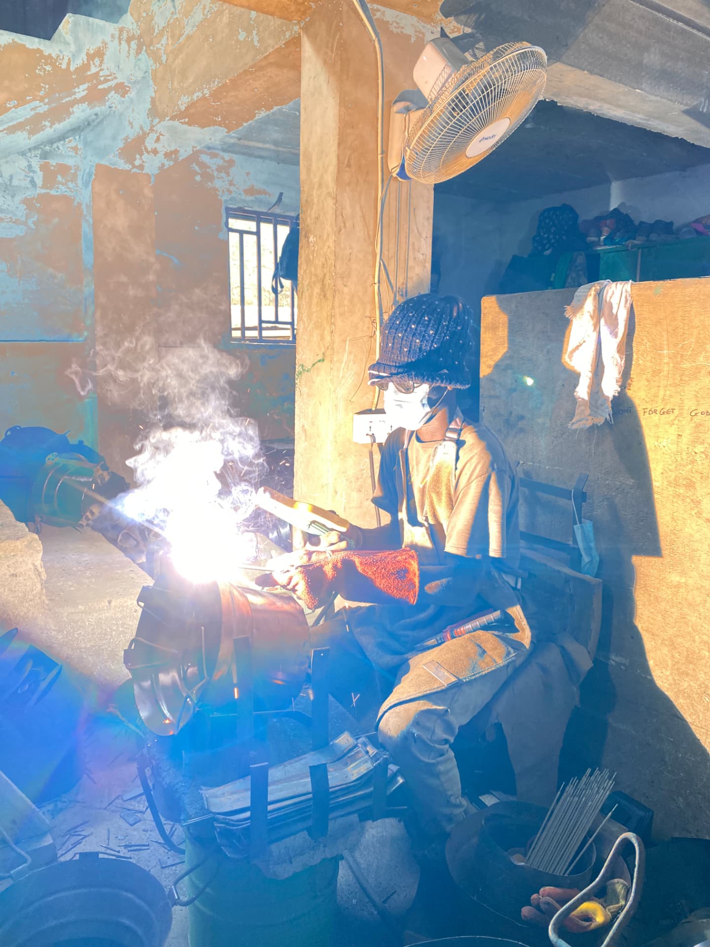 A CookClean production team member welding a stove in the factory